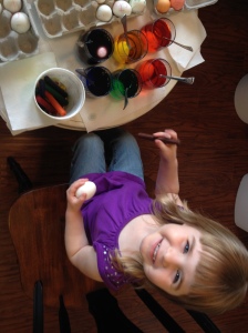Happy girl coloring eggs for Easter!